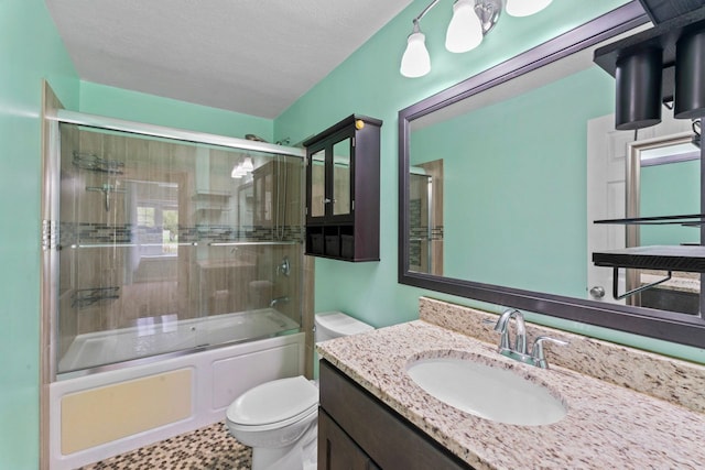 full bathroom with toilet, vanity, bath / shower combo with glass door, and a textured ceiling