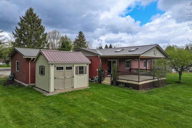 rear view of house with a lawn, a storage unit, an outbuilding, a deck, and metal roof