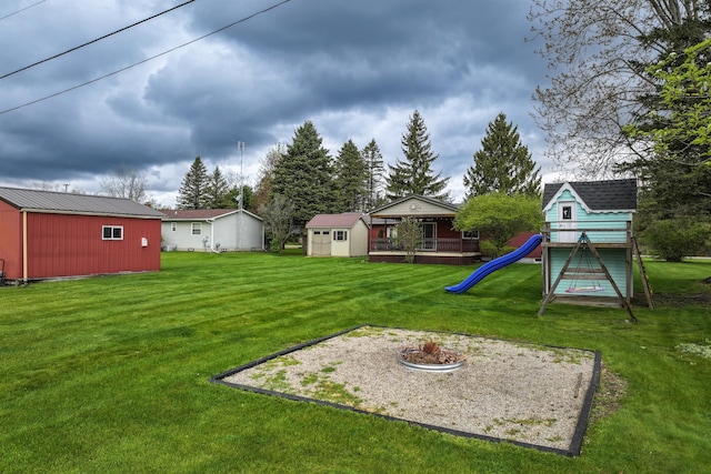 view of grassy yard with a storage unit, an outdoor structure, and a playground