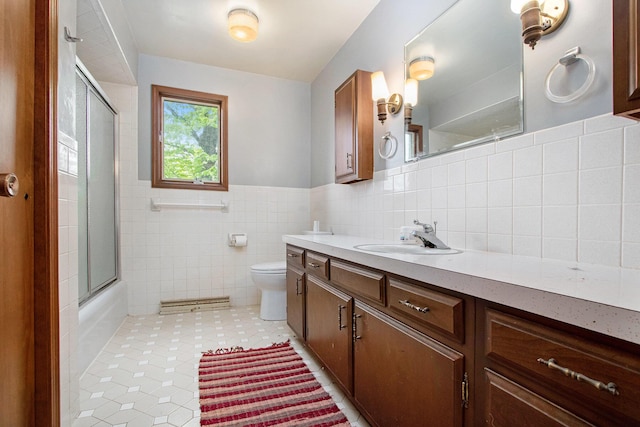 full bath featuring toilet, tile walls, vanity, tile patterned flooring, and combined bath / shower with glass door