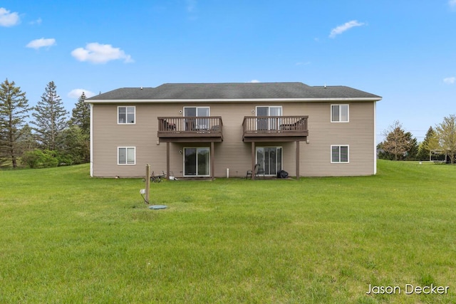 back of house featuring a lawn and a wooden deck