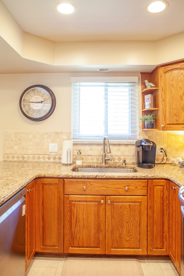 kitchen featuring dishwasher, a sink, light stone countertops, light tile patterned flooring, and recessed lighting