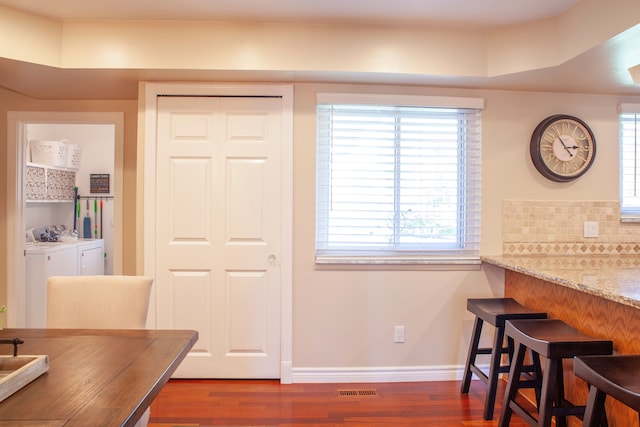 dining space featuring separate washer and dryer, wood finished floors, and healthy amount of natural light