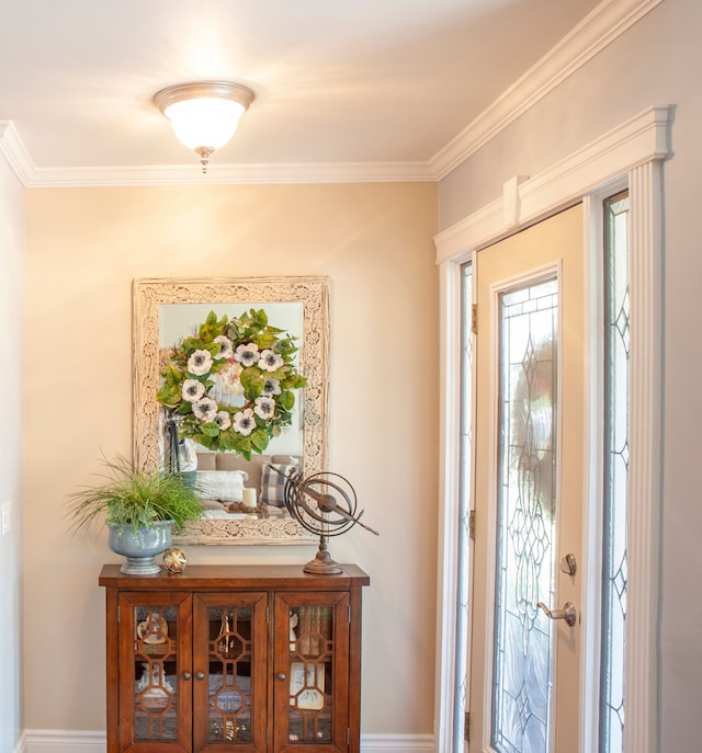 entrance foyer with ornamental molding and baseboards