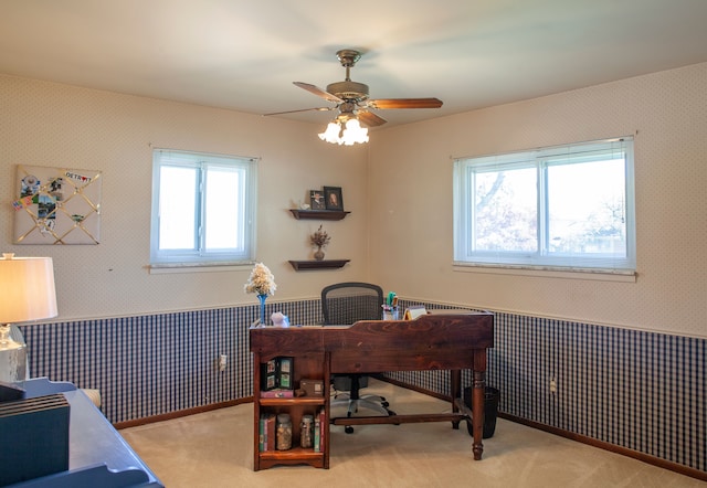 office area with wallpapered walls, wainscoting, ceiling fan, and carpet flooring