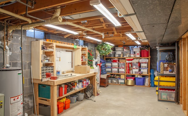 unfinished below grade area featuring water heater and a workshop area