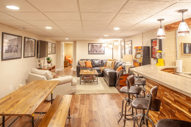 living room featuring bar area, light wood-type flooring, and recessed lighting