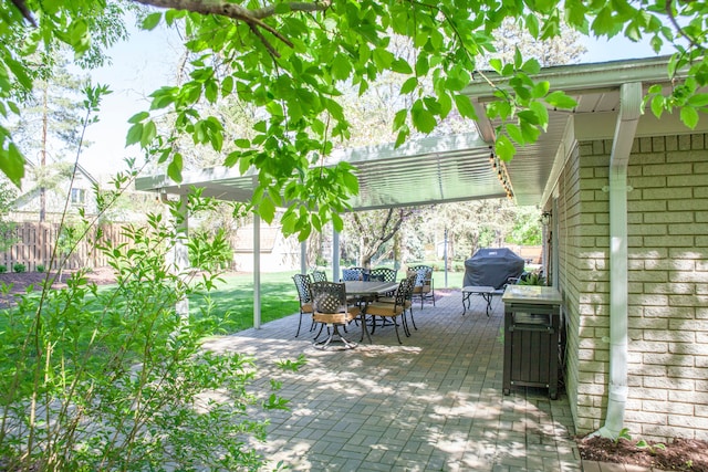 view of patio / terrace featuring outdoor dining space, fence, and a grill