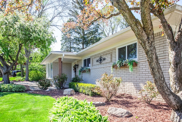 ranch-style home featuring brick siding and a front lawn