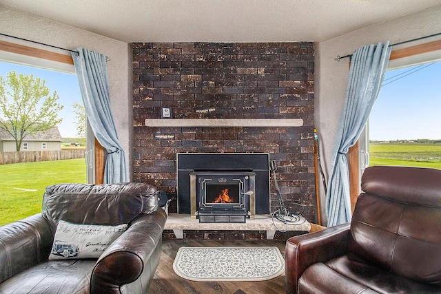 living area featuring plenty of natural light, wood finished floors, and a fireplace