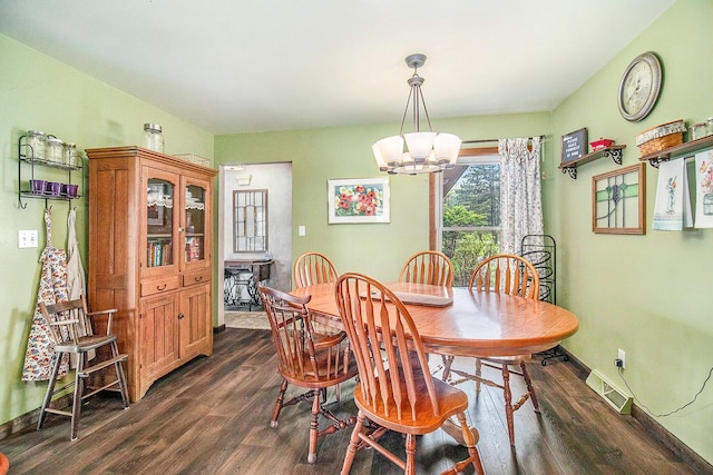 dining space with dark wood-style floors, a chandelier, and baseboards