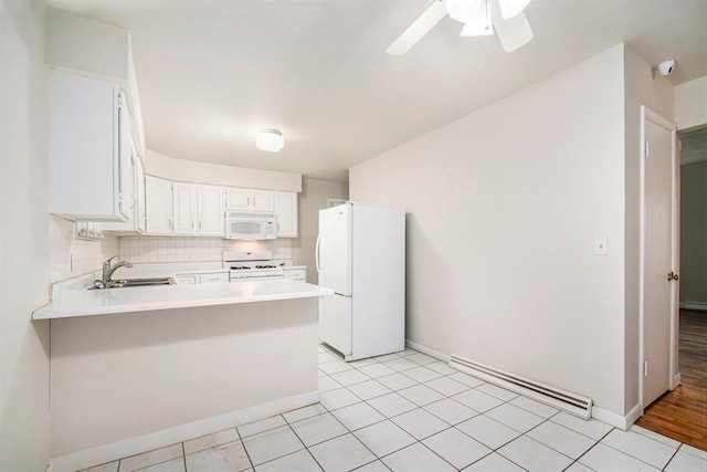 2 Fort St, Niles, MI 49120 - kitchen with white appliances, a peninsula, light countertops, a sink, and baseboards