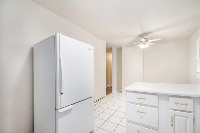 2 Fort St, Niles, MI 49120 - kitchen featuring freestanding refrigerator, ceiling fan, light countertops, light tile patterned flooring, and white cabinetry
