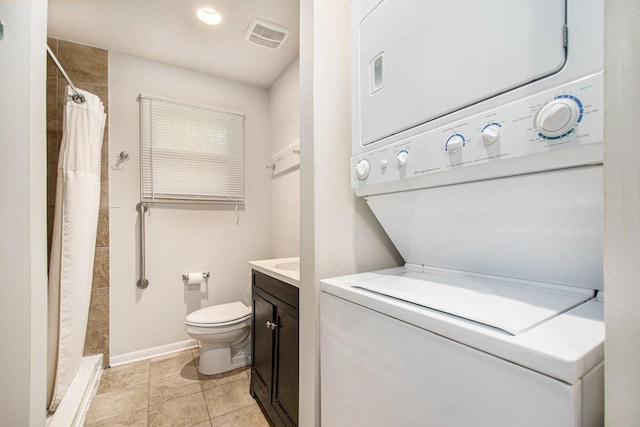 2 Fort St, Niles, MI 49120 - bathroom with estacked washer and dryer, toilet, tiled shower, vanity, and baseboards