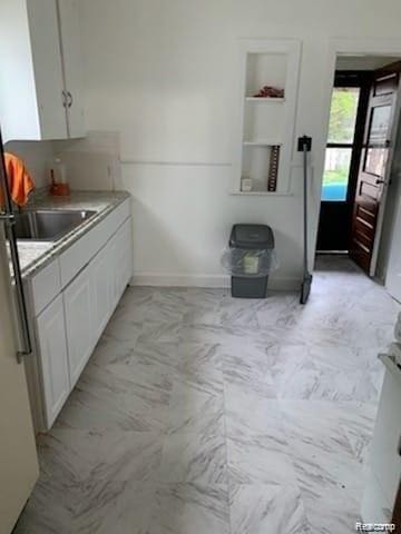 8097 Marlowe St, Detroit, MI 48228 - kitchen featuring freestanding refrigerator, white cabinets, light countertops, and light marble finish flooring