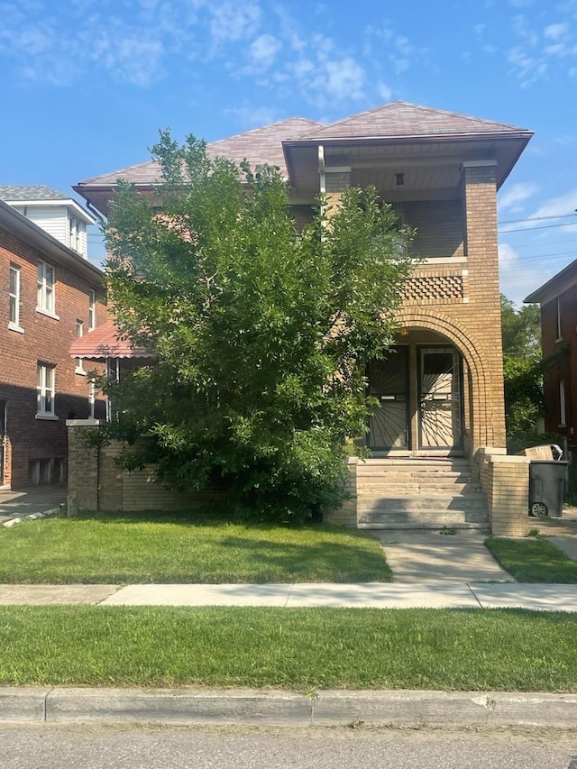 view of front of house with brick siding and a front yard