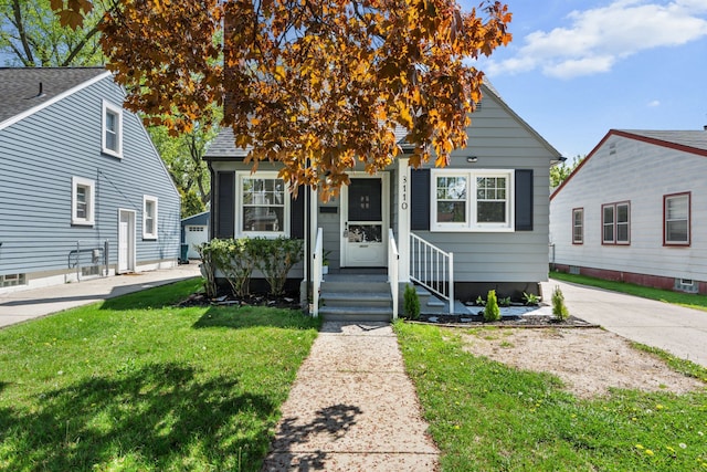bungalow-style house featuring a front lawn