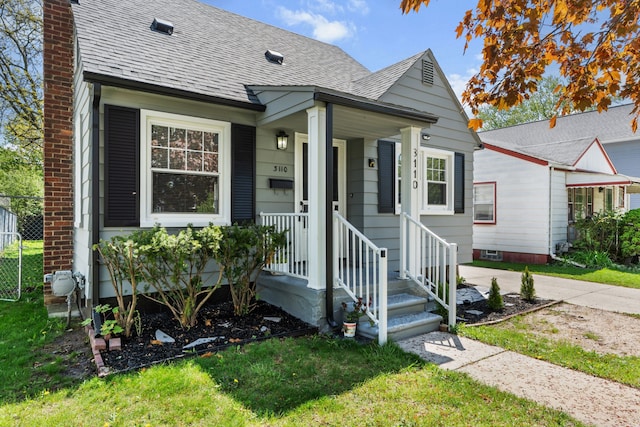 view of front of home featuring a shingled roof, a chimney, and a front yard