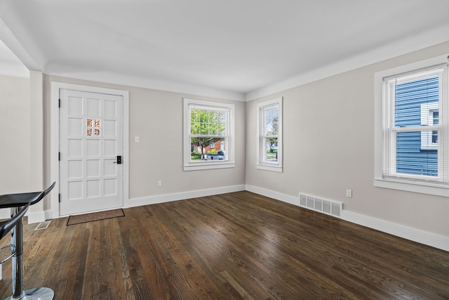 foyer with dark wood-style flooring and baseboards