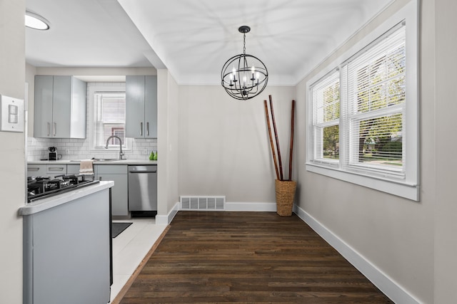 dining area featuring healthy amount of natural light, a chandelier, baseboards, and wood finished floors