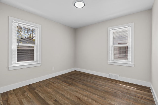 empty room with baseboards and dark wood-style flooring