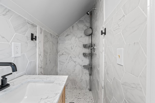 full bath featuring tiled shower, tile walls, and vanity