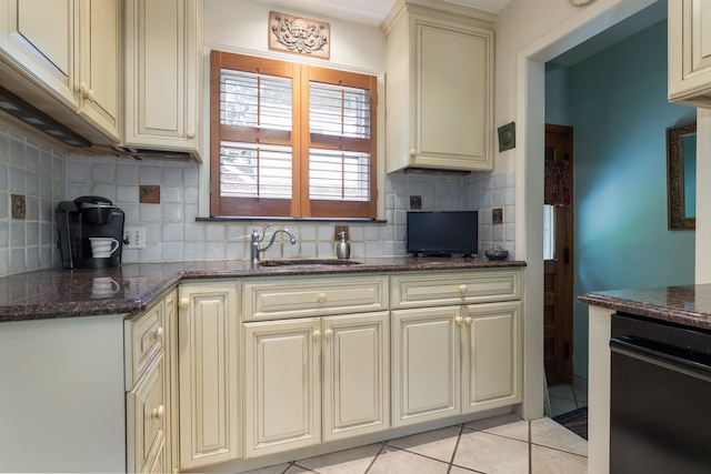 kitchen featuring cream cabinets, tasteful backsplash, and a sink