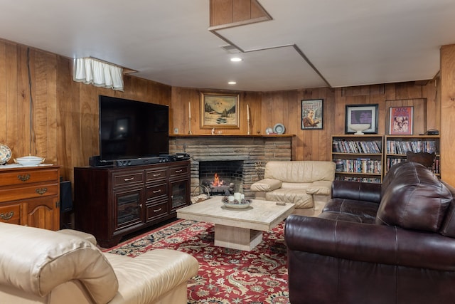 living area featuring wood walls and a stone fireplace