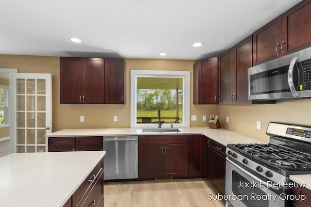 12840 Ridgedale Dr, Allendale, MI 49401 - kitchen with appliances with stainless steel finishes, a sink, light countertops, light wood-style floors, and recessed lighting