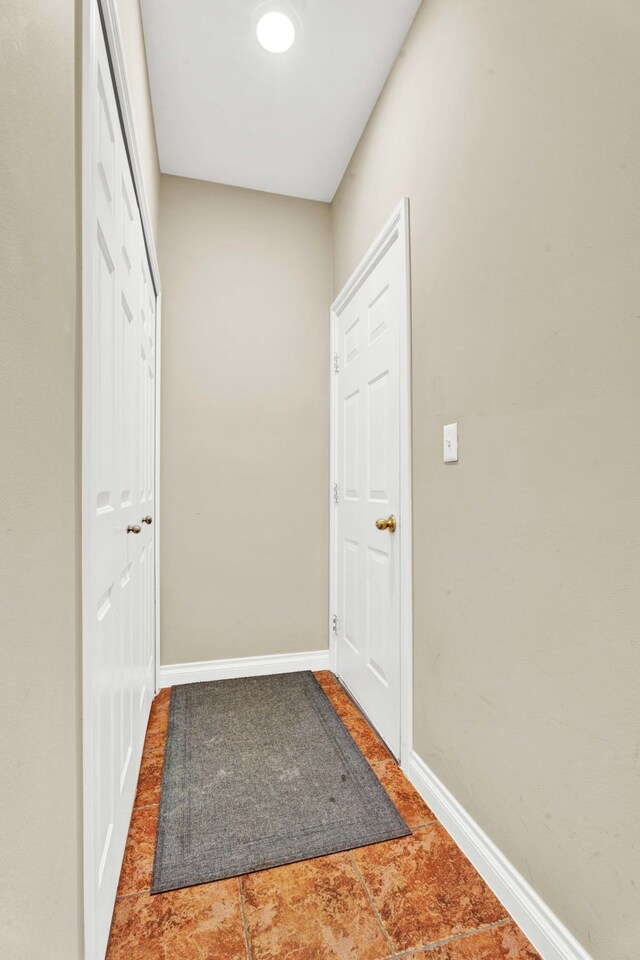 doorway featuring baseboards