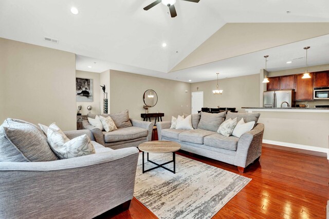 living area featuring vaulted ceiling, wood finished floors, recessed lighting, ceiling fan, and a chandelier