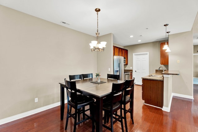 dining area featuring wood-type flooring, a chandelier, baseboards, and recessed lighting