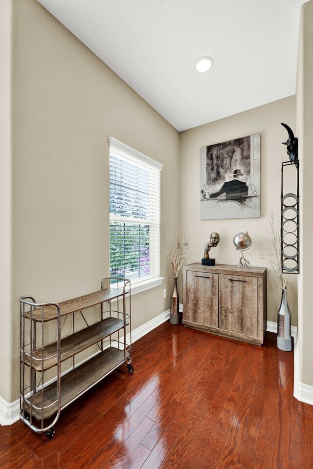 living area with baseboards, wood finished floors, and an office area
