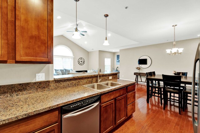 kitchen with stainless steel dishwasher, a sink, wood finished floors, hanging light fixtures, and a ceiling fan
