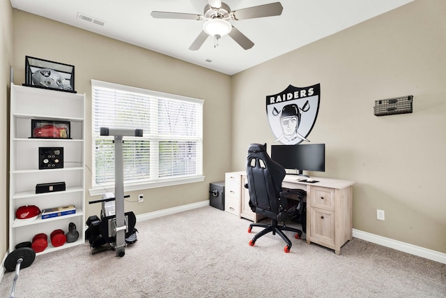 carpeted office with baseboards and a ceiling fan