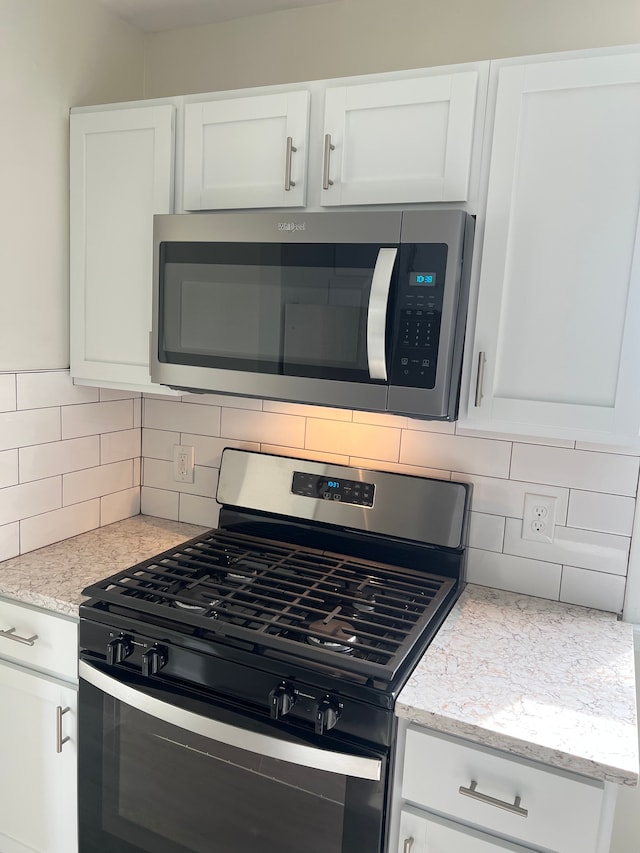 11389 Hupp Ave, Warren, MI 48089 - kitchen view of appliances with stainless steel finishes, decorative backsplash, and white cabinets