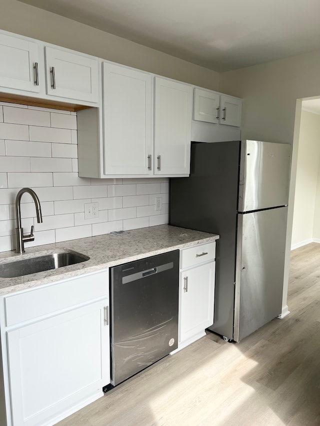 11389 Hupp Ave, Warren, MI 48089 - kitchen featuring stainless steel appliances, a sink, light wood-style flooring, white cabinets, and light stone countertops