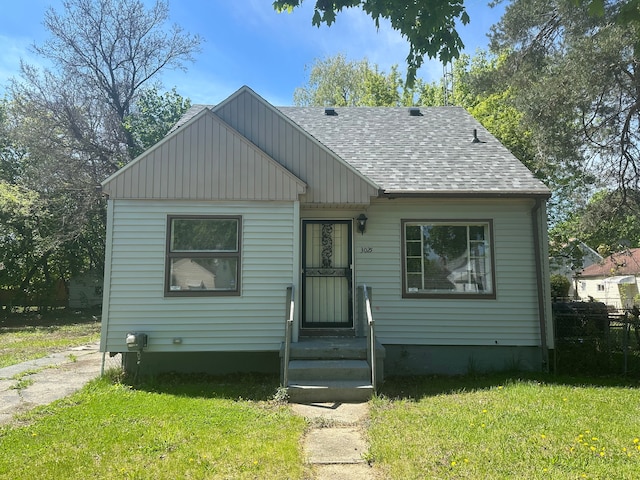 bungalow-style house with a shingled roof and a front yard