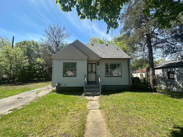 bungalow-style house featuring a front yard and a shingled roof