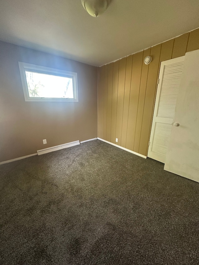 carpeted spare room featuring baseboard heating and baseboards