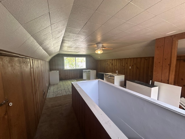 additional living space featuring wooden walls, lofted ceiling, and ceiling fan