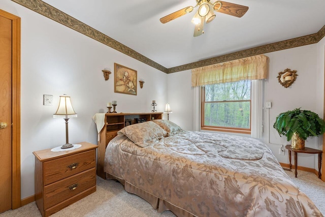 bedroom featuring light carpet, baseboards, and a ceiling fan