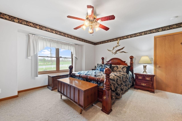 bedroom featuring light carpet, a ceiling fan, and baseboards