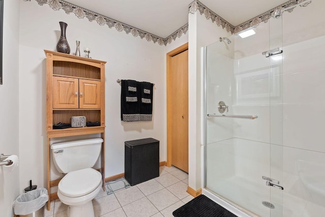 full bathroom featuring a stall shower, toilet, baseboards, and tile patterned floors
