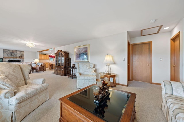 living room with carpet, a fireplace, attic access, and baseboards