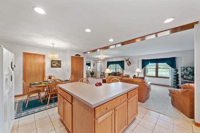 kitchen featuring white refrigerator with ice dispenser, light tile patterned floors, open floor plan, recessed lighting, and light countertops