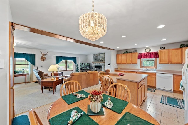 dining area with healthy amount of natural light, light tile patterned floors, recessed lighting, a chandelier, and a fireplace
