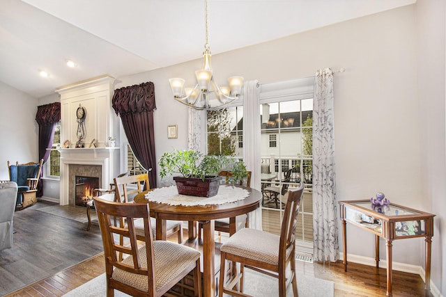 4261 Merriman Loop, Howell, MI 48843 - dining area with a chandelier, wood finished floors, baseboards, a large fireplace, and recessed lighting