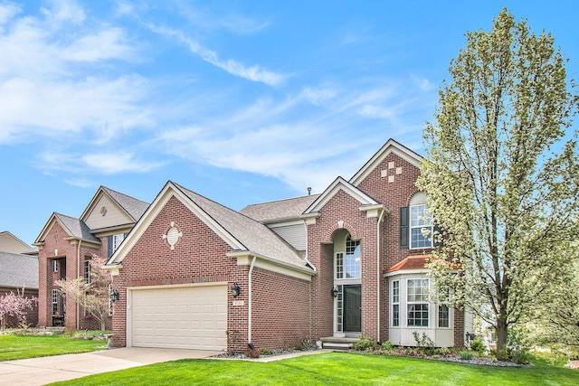 4261 Merriman Loop, Howell, MI 48843 - traditional-style house featuring a front lawn, driveway, brick siding, a garage, and roof with shingles