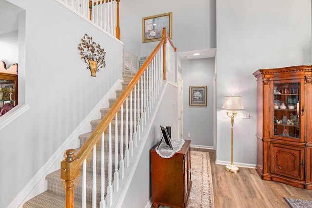 4261 Merriman Loop, Howell, MI 48843 - stairway with wood finished floors, a towering ceiling, and baseboards
